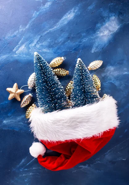 Noworoczne Dekoracje Czerwony Kapelusz Świętego Mikołaja Dekoracyjne Niebieskie Drzewa Szyszki — Zdjęcie stockowe