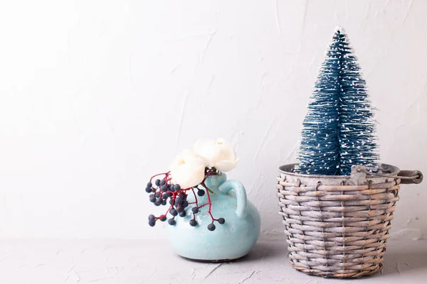お祭りの冬のポストカード 質感の壁に対して花瓶に装飾的な青い休日の木や野生の果実やバラの花 まだ生きてる クリスマスのコンセプト スペースのコピー — ストック写真