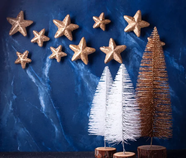 Decoratieve Witte Gouden Vakantiebomen Gouden Sterren Tegen Diepblauwe Getextureerde Muur — Stockfoto