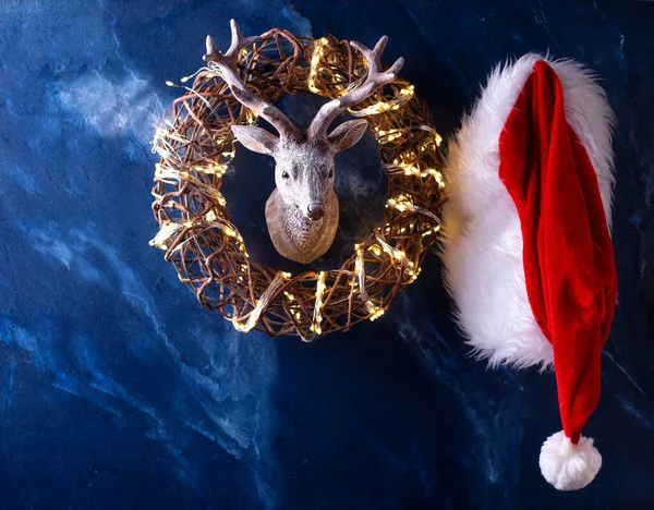 Noel Baba Şapkası Koyu Mavi Mırıldanma Arka Planında Geyik Başı — Stok fotoğraf