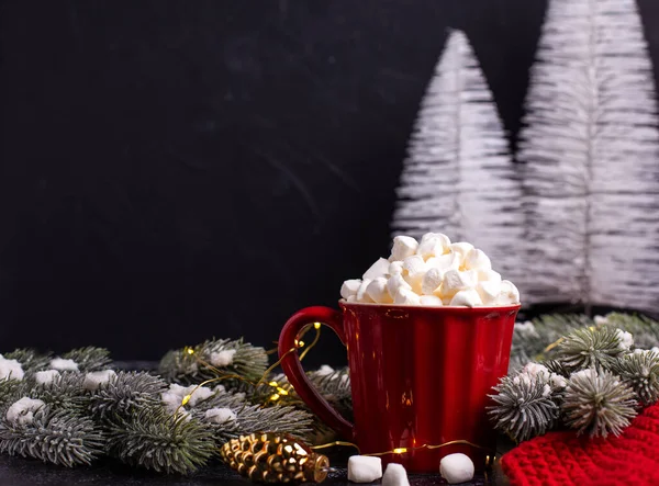 明亮的红色杯子 有热饮料和一堆的混和物和圣诞树的枝条 背景为黑色纹理 圣诞明信片 案文的位置 — 图库照片