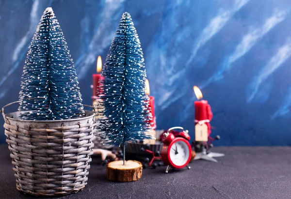 可爱的红色和蓝色圣诞装饰 蓝色装饰树在灰色的乡村桶 红色的时钟和燃烧的蜡烛蓝色纹理背景 斯堪的纳维亚简约主义风格 静谧的生活 — 图库照片