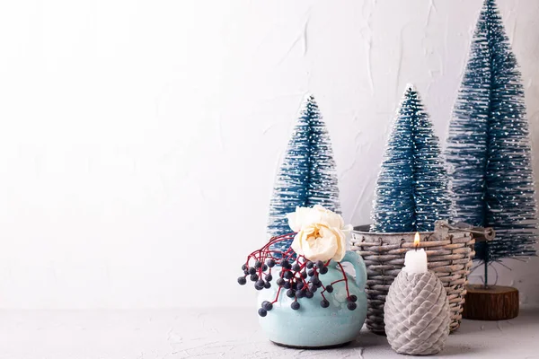 冬のポストカード 質感の壁に対して花瓶に装飾的な青い休日の木 燃えるキャンドル 野生の果実やバラの花 まだ生きてる クリスマスのコンセプト — ストック写真