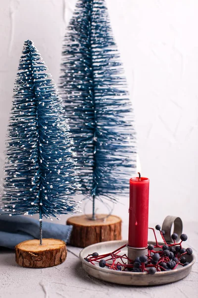 クリスマスの飾り 素朴なホルダー 広い青い果実と質感の背景に青い装飾の木で赤い燃焼キャンドル 北欧ミニマルなスタイル 静物画 — ストック写真