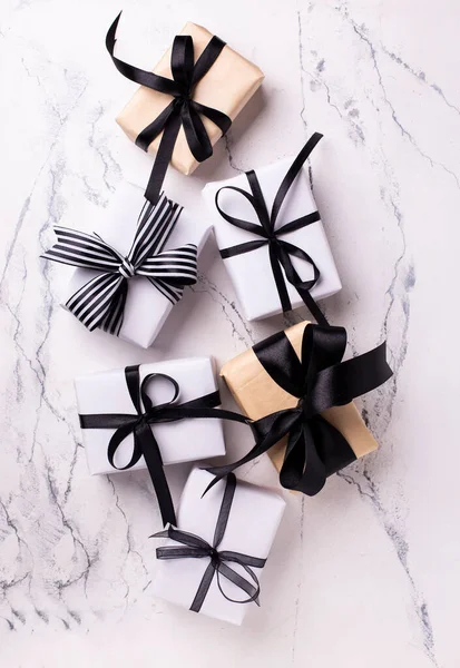 Set of boxes with wrapped  gifts  in black and white colors on white marble background. Top view. Place for text.