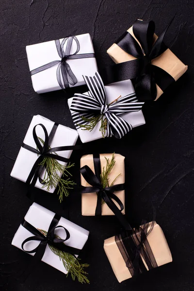 一套包装好的礼物 用黑色纹理背景的长青灌木和枝条包裹着 斯堪的纳维亚圣诞顶部视图 — 图库照片