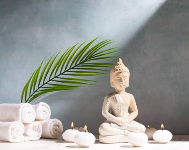 Sakinleştirici spa seti. Buda ve mavi desenli duvarda yanan küçük beyaz mumlar. Refah, zaman kavramı. Metin için yer.