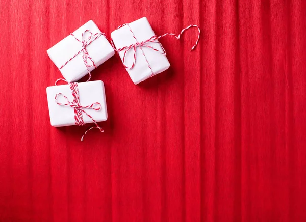 Drei Verpackte Schachteln Mit Geschenken Auf Rotem Strukturiertem Papier Hintergrund — Stockfoto