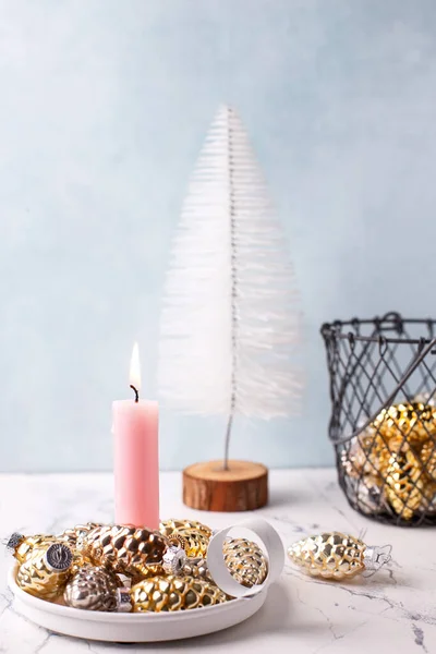 クリスマスポストカード 青いテクスチャの壁に対する白い装飾ツリー ピンクの燃焼キャンドル 黄金と銀の装飾コーン ピンクと金色のクリスマス 選択的フォーカス テキストの場所 — ストック写真