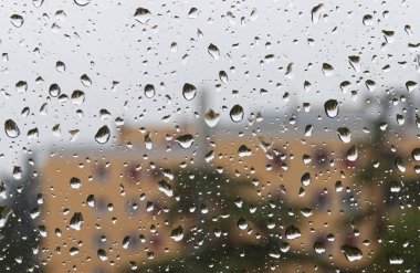Su damlacıkları saydam pencerede yoğunlaştı. Yağmur damlaları.