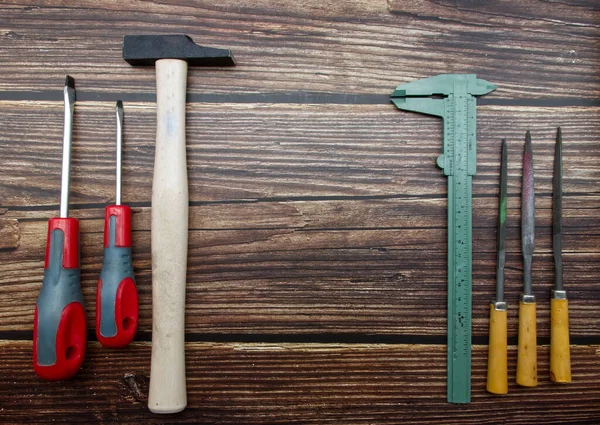 Woodworking tools: hammer, screwdrivers, wood files, gauge, isolated on wood background. Top view. Flat lay.