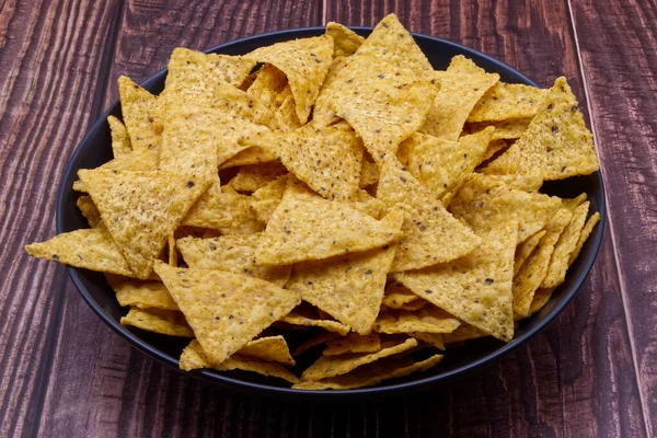 Nacho Een Zwarte Kom Tortilla Chips Houten Ondergrond — Stockfoto