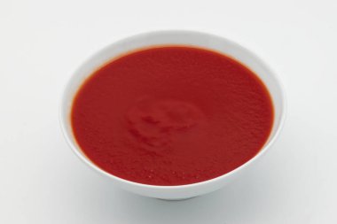 Beyaz arka planda bir kase taze domates sosu..