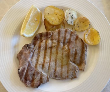 Kızarmış patatesli domuz pirzolası (Braciola di maiale alla griglia con patate).