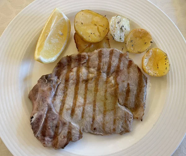 Kızarmış patatesli domuz pirzolası (Braciola di maiale alla griglia con patate).