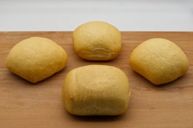 Ahşap masada yumuşak irmik ekmeği somunları.