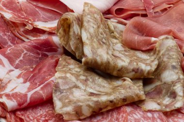 Ahşap arka planda çeşitli İtalyan salamlarının tabağı. Çeşit çeşit et..