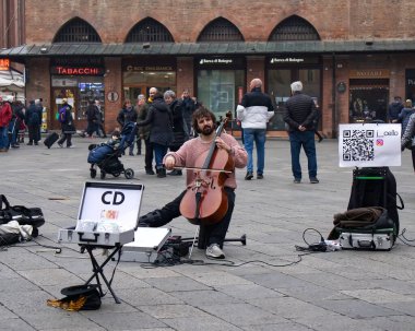 Bolonya - İtalya - 31 Aralık 2023: Busker Bologna 'da çello çalıyor. Sokakta sokak çalgıcılığı.