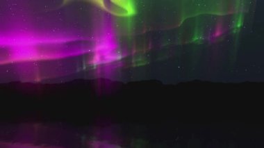 Görkemli Kuzey Işıkları Siluetli Dağların Üzerinde Dans Ediyor.