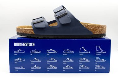 Bologna - İtalya - 12 Ocak 2025: Birkenstock tarzı çeşitli ayakkabıları sergileyen bir çift lacivert Birkenstock Arizona sandaletinin yakından görüntüsü.
