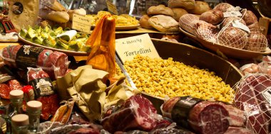 Bologna - İtalya - 27 Aralık 2024: Taze İtalyan yemekleri, çeşitli türde pişirilmiş etler, makarna (tortellini) ve ekmekler sergilenmektedir..