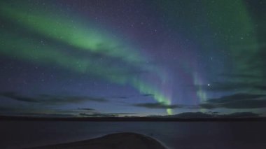 Kuzey Işıkları, gece gökyüzünde canlı aurora flamaları.