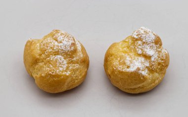 İki altın esmer kremalı pudra şekerli pudra pudrası temiz bir yüzeyde keyif bekliyor..