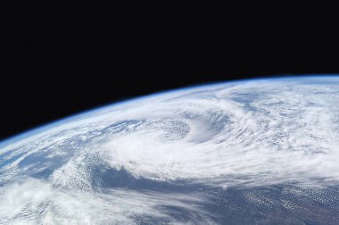 Dünya 'nın okyanusları ve kıtaları üzerinde uzaydan dönen güçlü bir kasırganın yıldızlı görüntüsü.