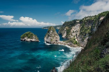 Nusa Penida 'daki kayalıklardan ve turkuaz sudan oluşan bir kıyı manzarası.