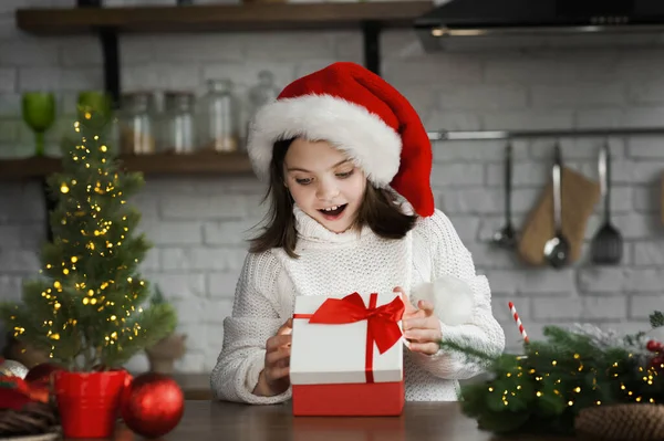 メリークリスマスとハッピーニューイヤー2023 幸せな女の子は ライトの背景に贈り物を開きます — ストック写真