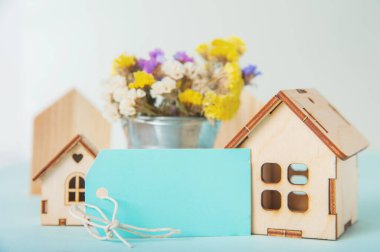 Mutlu Paskalya tebrik kartları. Minyatür ahşap ev. Tavşanlar, renkli yumurtalar, yazı için etiketli bahar çiçekleri..