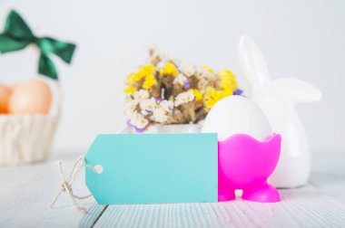 Mutlu Paskalya tebrik kartları. Tavşanlar, renkli yumurtalar, metin için etiketli bahar çiçekleri.