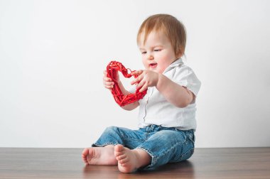 Toddler boy 11 months old with heart in his hands for Valentine's Day.