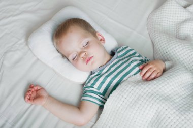 Küçük çocuk, yatakta yakın çekimde uyuyor. Sağlık hizmeti kavramı.