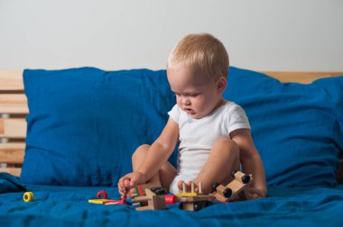 Küçük çocuk, ahşap inşaatçı treniyle yakın planda oynuyor...