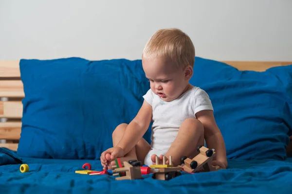 Kleinkind Spielt Mit Holzbaufahrzeug Auf Bett Großaufnahme — Stockfoto