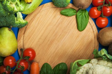 Taze sebzelerden yapılmış kalp ve ahşap arka planda meyve..