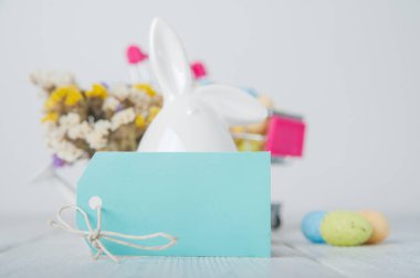 Mutlu Paskalya tebrik kartları. Tavşanlar, renkli yumurtalar, metin için etiketli bahar çiçekleri.