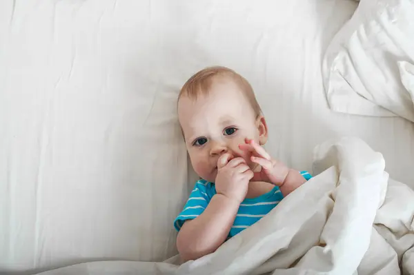 Baby 11 months old on the bed getting ready to sleep