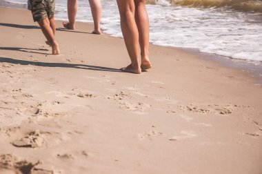 Tüm ailenin bacakları sahil boyunca uzayda koşuyor ve kopyalanıyor. yaz denizi geçmişi