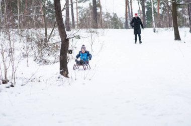 Baba ve oğul kışın kızak kayıyor..
