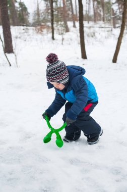Küçük çocuk kartopu oynuyor. Kış açık hava aktivitesi.