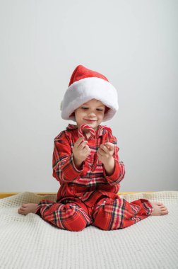 Noel 'de Noel Baba Şapkalı Sevimli Çocuk Şeker Çubukları Tutuyor.