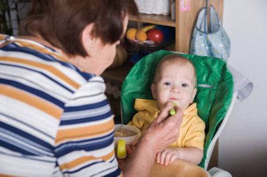 Mutlu Bebek Evde Büyükanne Tarafından Besleniyor.