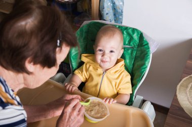 Mutlu Bebek Evde Büyükanne Tarafından Besleniyor.
