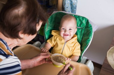Mutlu Bebek Evde Büyükanne Tarafından Besleniyor.
