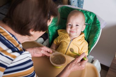 Mutlu Bebek Evde Büyükanne Tarafından Besleniyor.