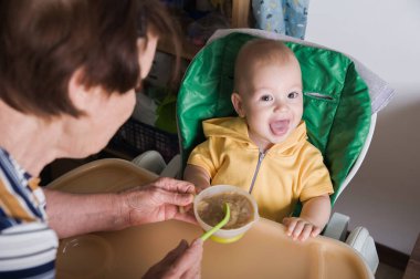 Mutlu Bebek Evde Büyükanne Tarafından Besleniyor.