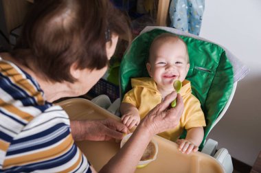 Mutlu Bebek Evde Büyükanne Tarafından Besleniyor.
