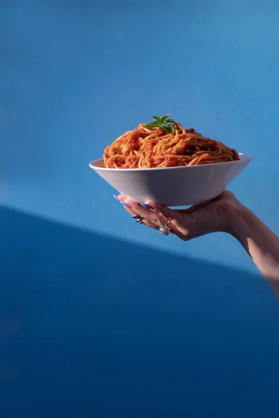 Női Kéz Kezében Egy Tányér Spagetti Tészta Paradicsommártással Fehér Tányéron Stock Kép